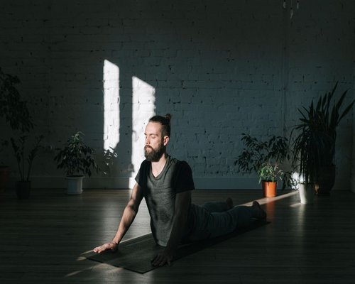Person doing gentle yoga poses on a mat indoors